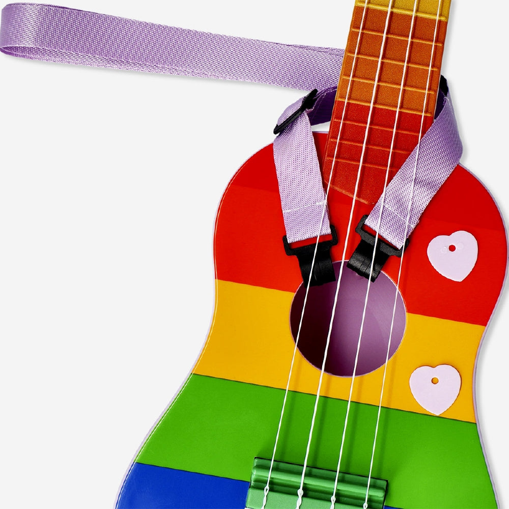 Rainbow-colored ukulele with strap by Flying Tiger Copenhagen, showing the vibrant instrument and attached strap.