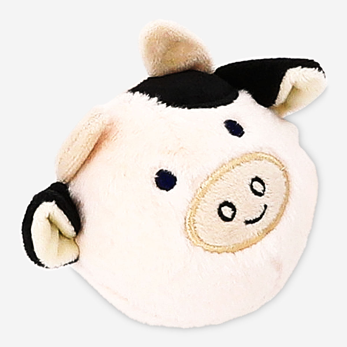 Soft plush ball toy in the shape of a cow from Flying Tiger Copenhagen, featuring a cute cow face and pastel-colored patches.