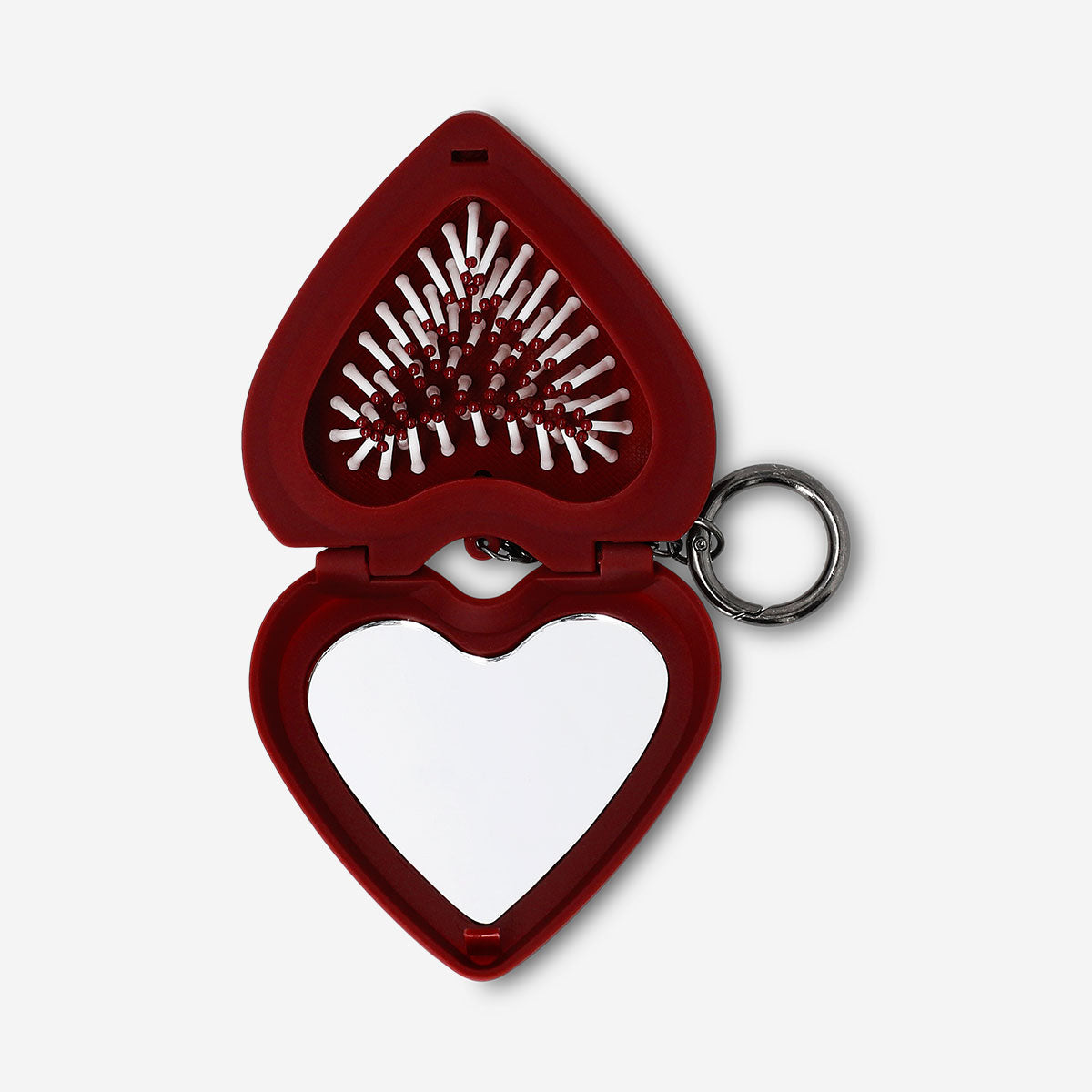 Foldable heart-shaped hairbrush with mirror by Flying Tiger Copenhagen, personal care accessory for easy styling on the go.