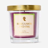 Flying Tiger Copenhagen scented candle with bergamot and fig fragrance, featuring a sleek glass jar and lit wick for home ambiance.