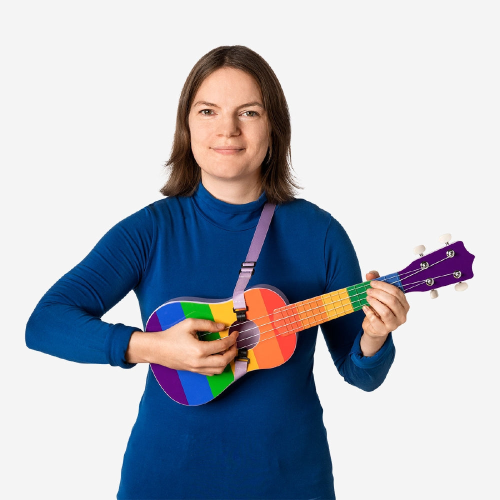 Colorful Rainbow ukulele with strap by Flying Tiger Copenhagen, showing the vibrant instrument and its adjustable strap.