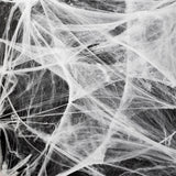 White spider cobweb decoration for parties, measuring 70x400 cm, by Flying Tiger Copenhagen, shown hanging with a spooky theme.