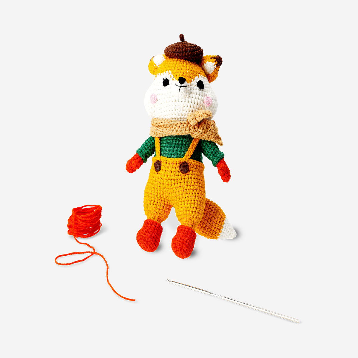 Crochet kit featuring a fox in a dress, by Flying Tiger Copenhagen, with colorful yarns and crochet tools arranged for crafting.