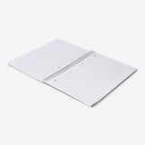 A4 spiral-bound grid notebook with a craft paper cover from Flying Tiger Copenhagen, shown open with visible grid pages inside.