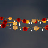 Red and white pompom string lights for home decor by Flying Tiger Copenhagen, featuring colorful, festive lighting for interior spaces.