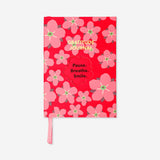 Red floral gratitude journal from Flying Tiger Copenhagen, featuring a decorative cover with vibrant floral patterns.