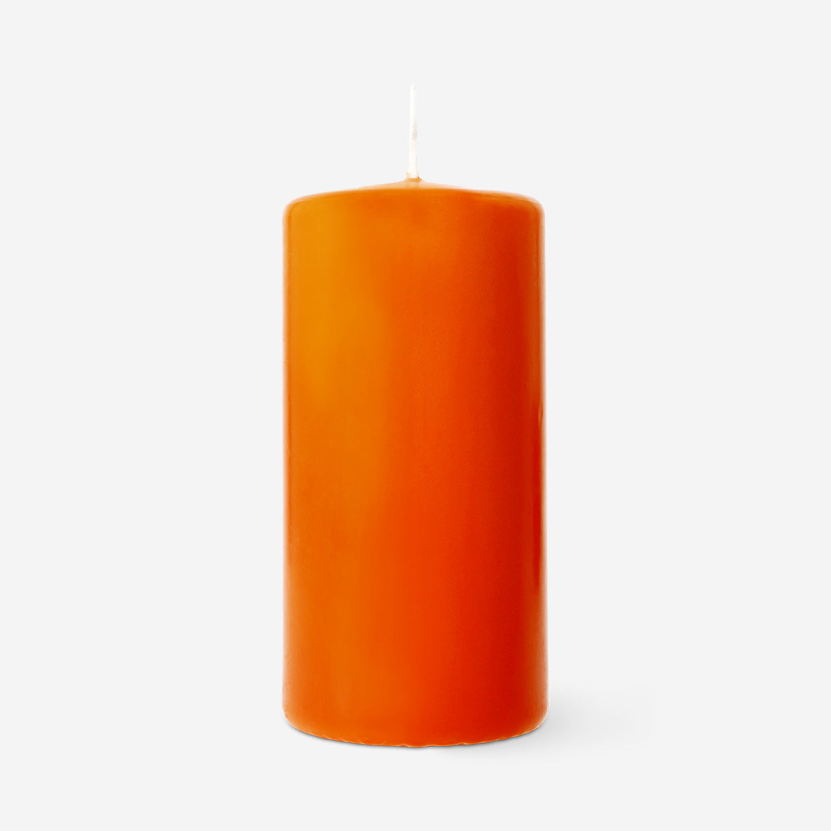 Orange pillar candle from Flying Tiger Copenhagen, 14 cm tall, shown on a home decor setting.