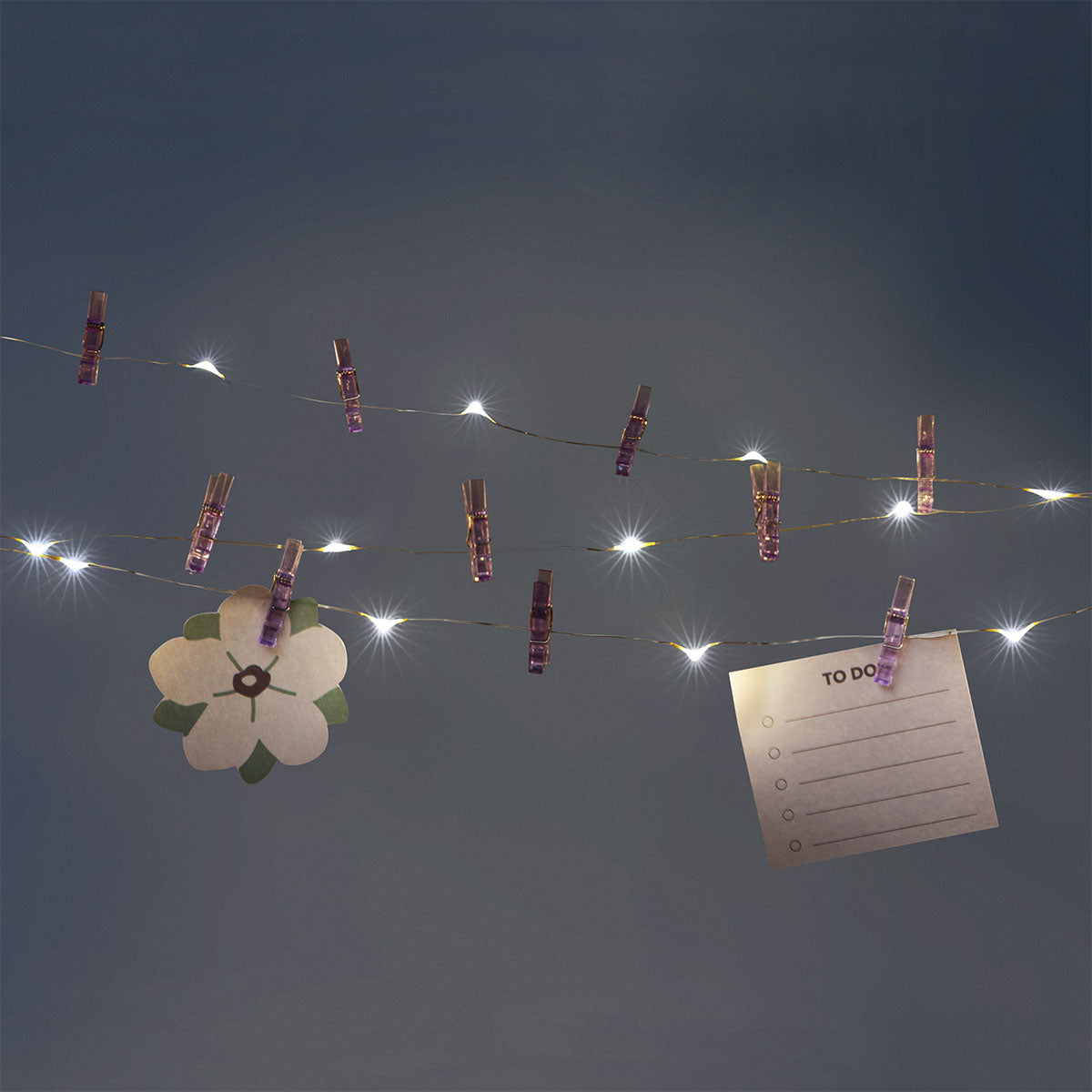 Purple string lights with clips from Flying Tiger Copenhagen, ideal for home decor and ambient lighting.