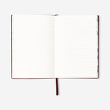 Burgundy office notebook with printed text, branded by Flying Tiger Copenhagen, open showing lined pages inside.