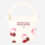 Set of cherry-colored makeup blender sponges in a Flying Tiger Copenhagen box for flawless personal care application.