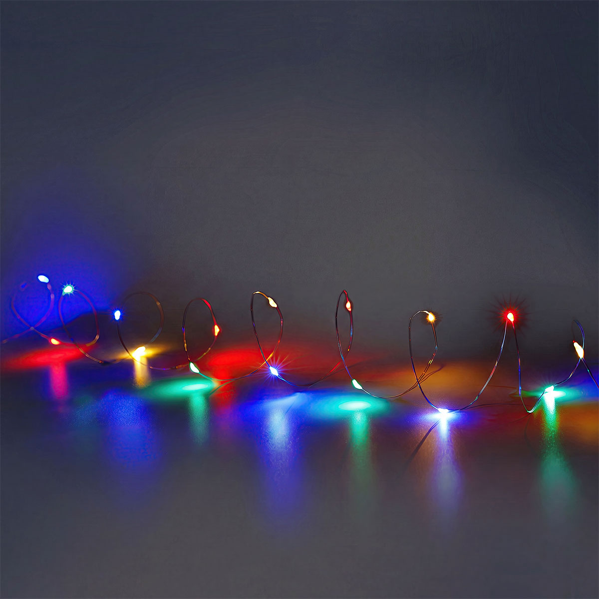 Multi-colored Flying Tiger Copenhagen string lights for home decoration, featuring vibrant bulbs hanging in a cozy indoor setting.