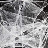 White spider cobweb decoration for parties, measuring 70x400 cm, from Flying Tiger Copenhagen, displayed hanging with a spooky theme.
