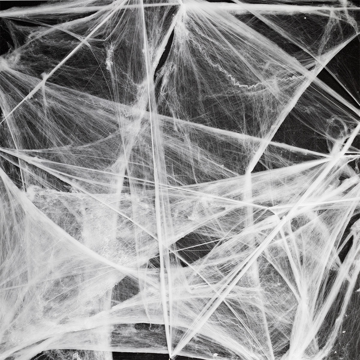 White spider cobweb decoration for parties, measuring 70x400 cm, from Flying Tiger Copenhagen, displayed hanging with a spooky theme.