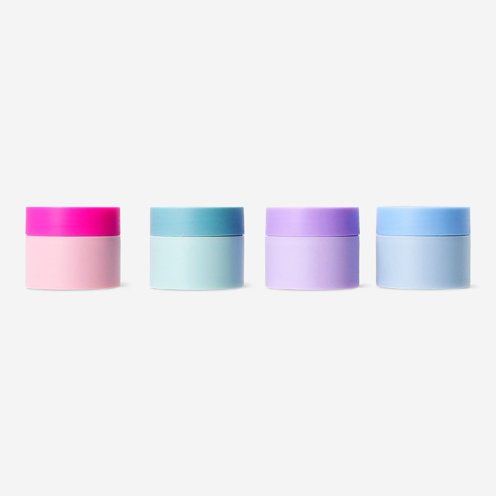 Set of four Flying Tiger Copenhagen travel jars with colorful stickers for leisure use, perfect for storing small toiletries or snacks.