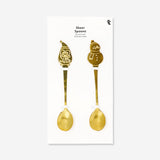 Two kitchen spoons with ski village design from Flying Tiger Copenhagen, featuring detailed winter scenes.