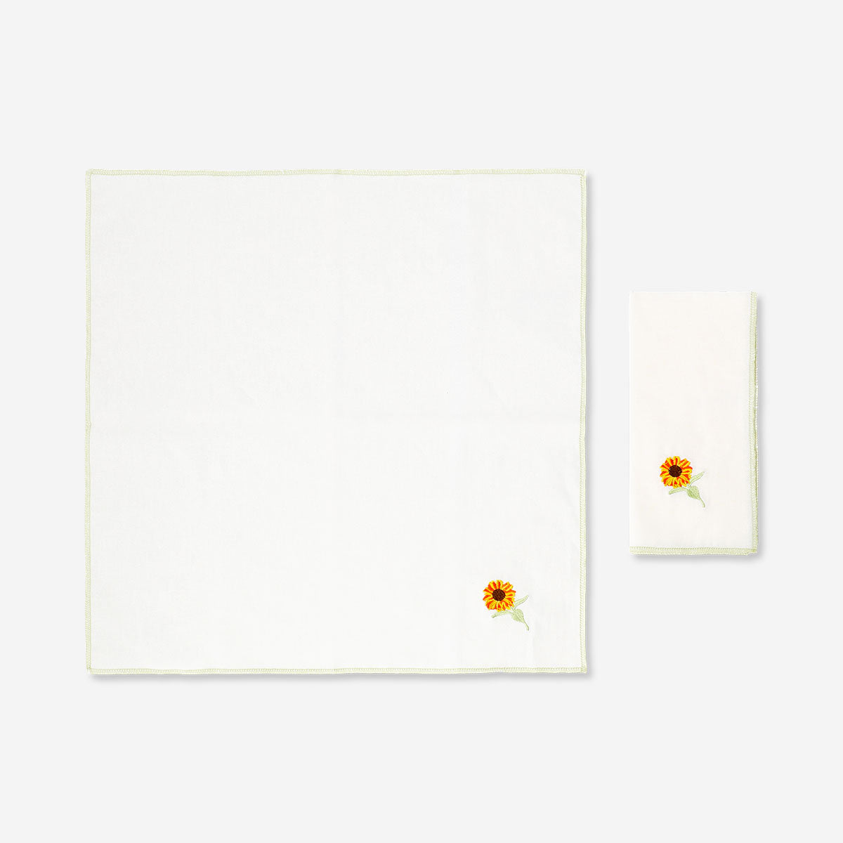 Pair of fabric napkins with embroidered sunflowers from Flying Tiger Copenhagen, featuring vibrant sunflower embroidery on soft fabric.