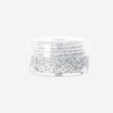 Silver glitter eyeshadow flakes from Flying Tiger Copenhagen, close-up of shimmering, iridescent cosmetic flakes for eye makeup.