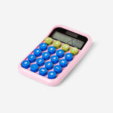 Pink solar-powered office calculator by Flying Tiger Copenhagen with digital display and functional keys.