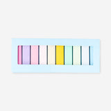 Multi-colored office page markers from Flying Tiger Copenhagen, spread out on a desk, showing vibrant, reusable bookmark strips.