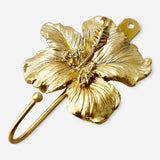 Gold flower-shaped hook from Flying Tiger Copenhagen for home decor and organization.