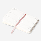Fabric cover weekly diary 2027 by Flying Tiger Copenhagen, opened to show weekly planning pages with fabric-textured cover.