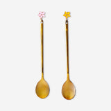 Two gold dessert spoons with delicate flower decorations from Flying Tiger Copenhagen, perfect for elegant table settings.