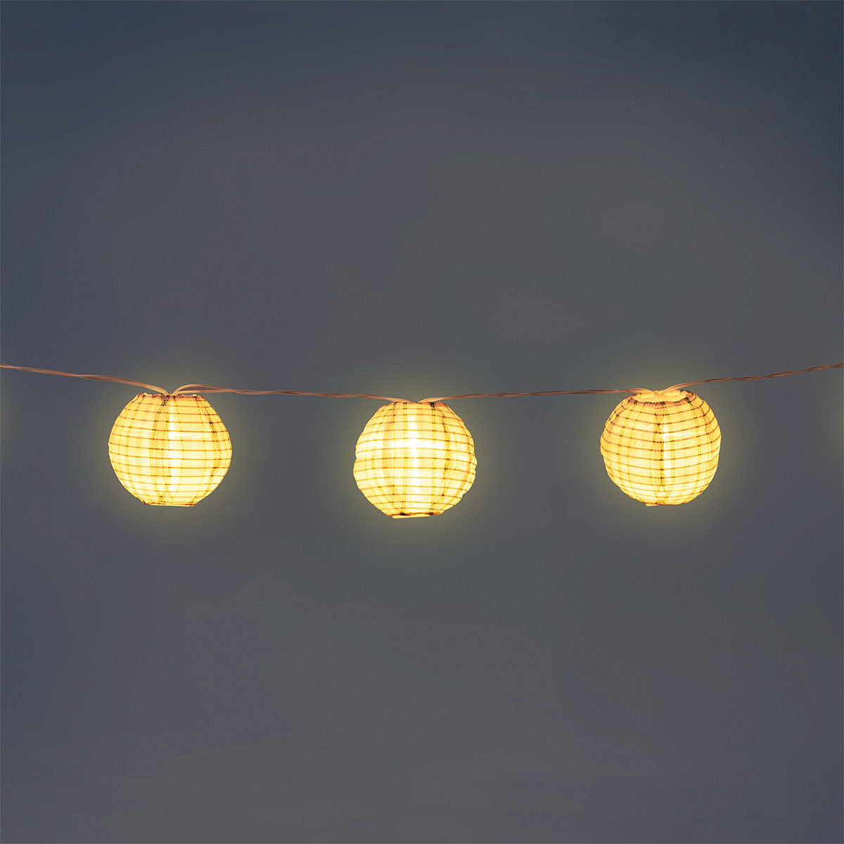 Outdoor string lights with striped fabric ball covers by Flying Tiger Copenhagen, perfect for garden or patio decor.