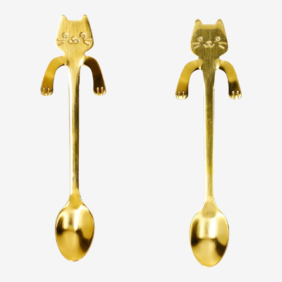 Set of two gold kitchen spoons with playful cat-shaped decorations, perfect for hanging on mugs, by Flying Tiger Copenhagen.