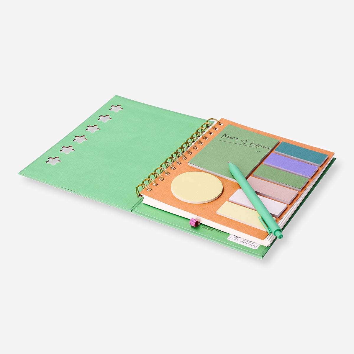 Green Flying Tiger Copenhagen office notebook with ballpoint pen and memo notes on a desk.