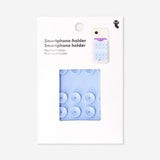 Blue smartphone holder with suction pads by Flying Tiger Copenhagen, mounted on a surface for hands-free media use.