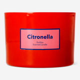 Flying Tiger Copenhagen scented outdoor candle with citronella fragrance, shown burning in a decorative holder for outdoor ambiance.