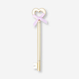 Gold ballpoint pen with a key and bow design, Flying Tiger Copenhagen office accessory, stylish writing instrument.