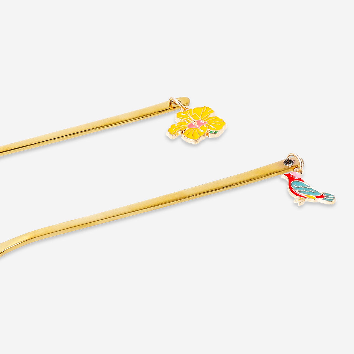 Two gold dessert spoons with tropical flower decorations from Flying Tiger Copenhagen, featuring elegant floral details.