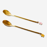 Pair of gold dessert spoons with delicate flower decorations from Flying Tiger Copenhagen, perfect for elegant dining.