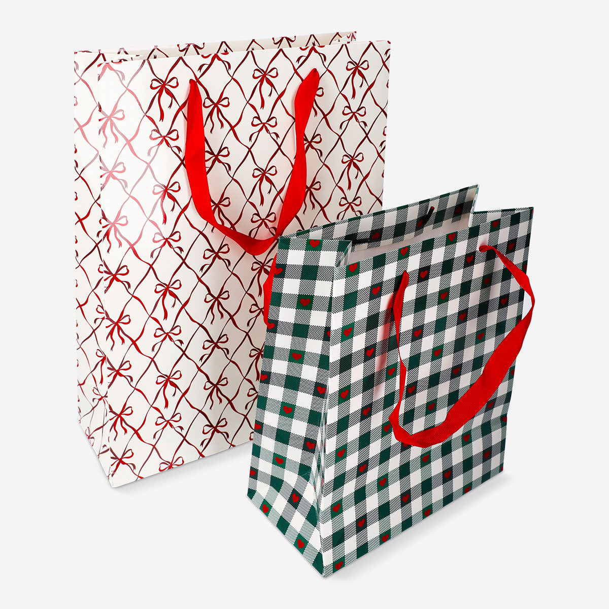 Two office gift bags with bow and heart print designs by Flying Tiger Copenhagen, featuring colorful patterns and handles.