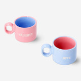 Two pastel ceramic cortado mugs with Christmas text from Flying Tiger Copenhagen, ideal for festive coffee occasions.