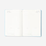 A5 blue daily diary 2027 by Flying Tiger Copenhagen, open to pages with date entries and planner sections.