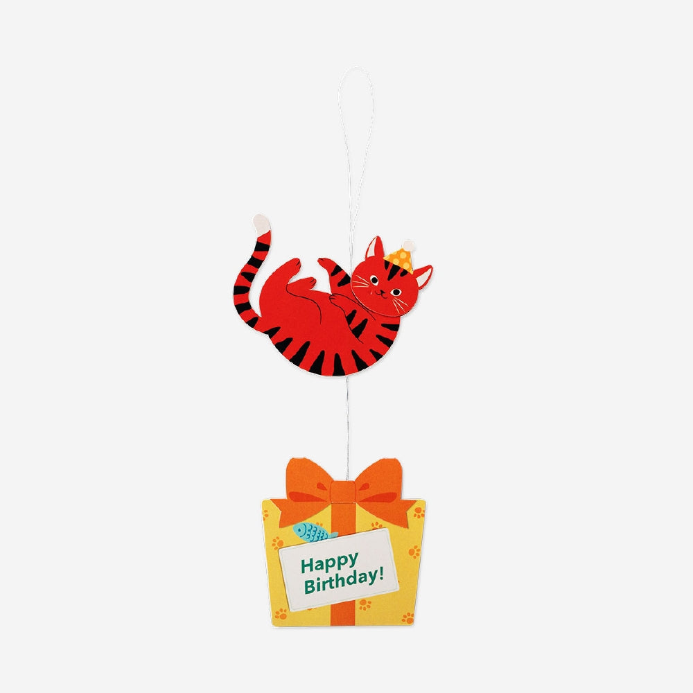 Office birthday card featuring a playful cat holding a present, from Flying Tiger Copenhagen.