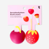 Two berry-shaped makeup brush covers in vibrant red and green, designed to protect and store makeup brushes.