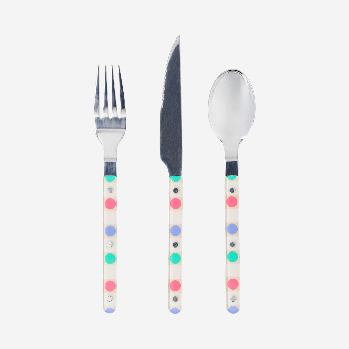 Set of three kitchen cutlery utensils with dotted handles from Flying Tiger Copenhagen on a neutral background.