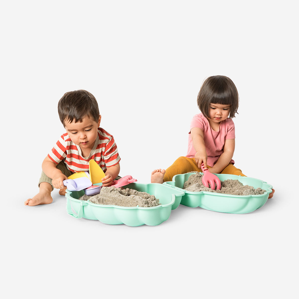 Flying Tiger Copenhagen clamshell sandbox toy with colorful sand moulds for outdoor play and creative sandcastle building.