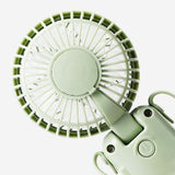 Green handheld fan with strap from Flying Tiger Copenhagen, compact gadget for personal cooling and easy carrying.