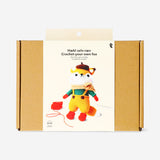 Crochet kit from Flying Tiger Copenhagen featuring a fox in a dress, with colorful yarn and crochet tools for crafting.
