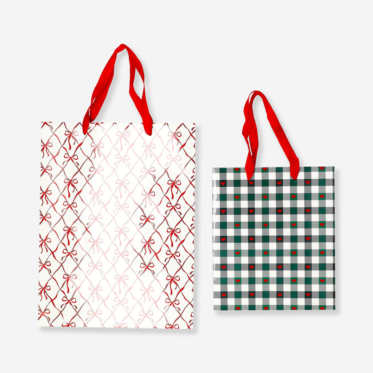 Two office gift bags with bow and heart print designs from Flying Tiger Copenhagen, featuring colorful patterns and sturdy handles.