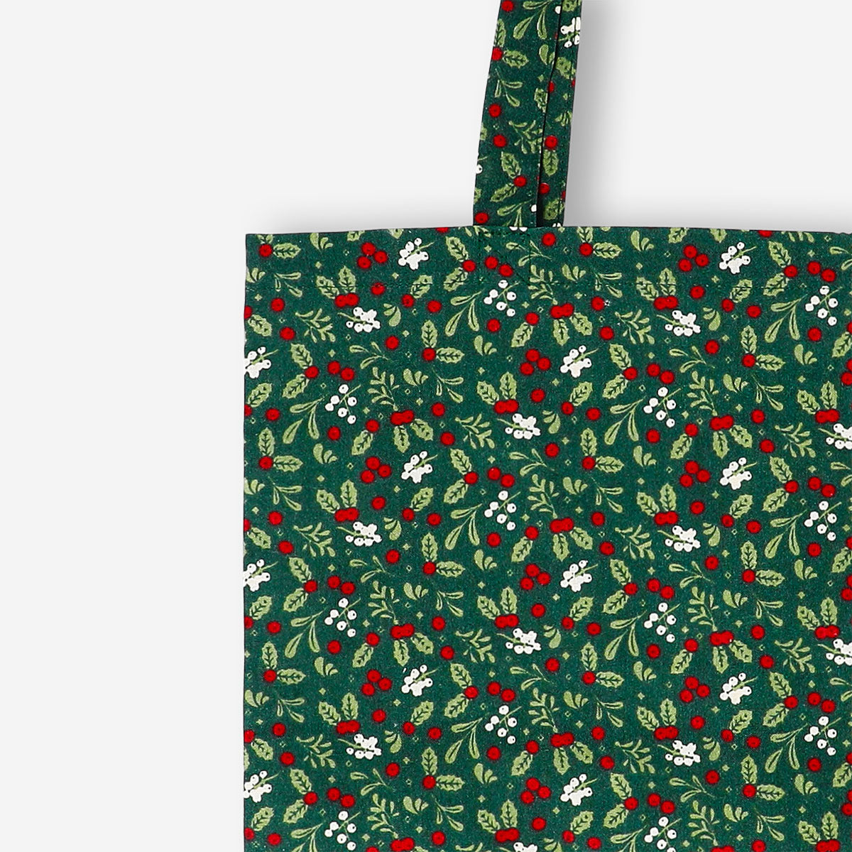 Green textile tote bag with holly leaf and berry patterns, designed by Flying Tiger Copenhagen.