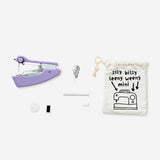 Purple handheld sewing machine by Flying Tiger Copenhagen, compact and suitable for hobby sewing projects.
