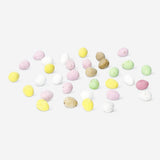 Chocolate mini eggs from Flying Tiger Copenhagen, colorful small candy eggs in a bowl on a white background.