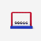 Blue and red Newton's cradle gadget from Flying Tiger Copenhagen with swinging metal balls on strings.