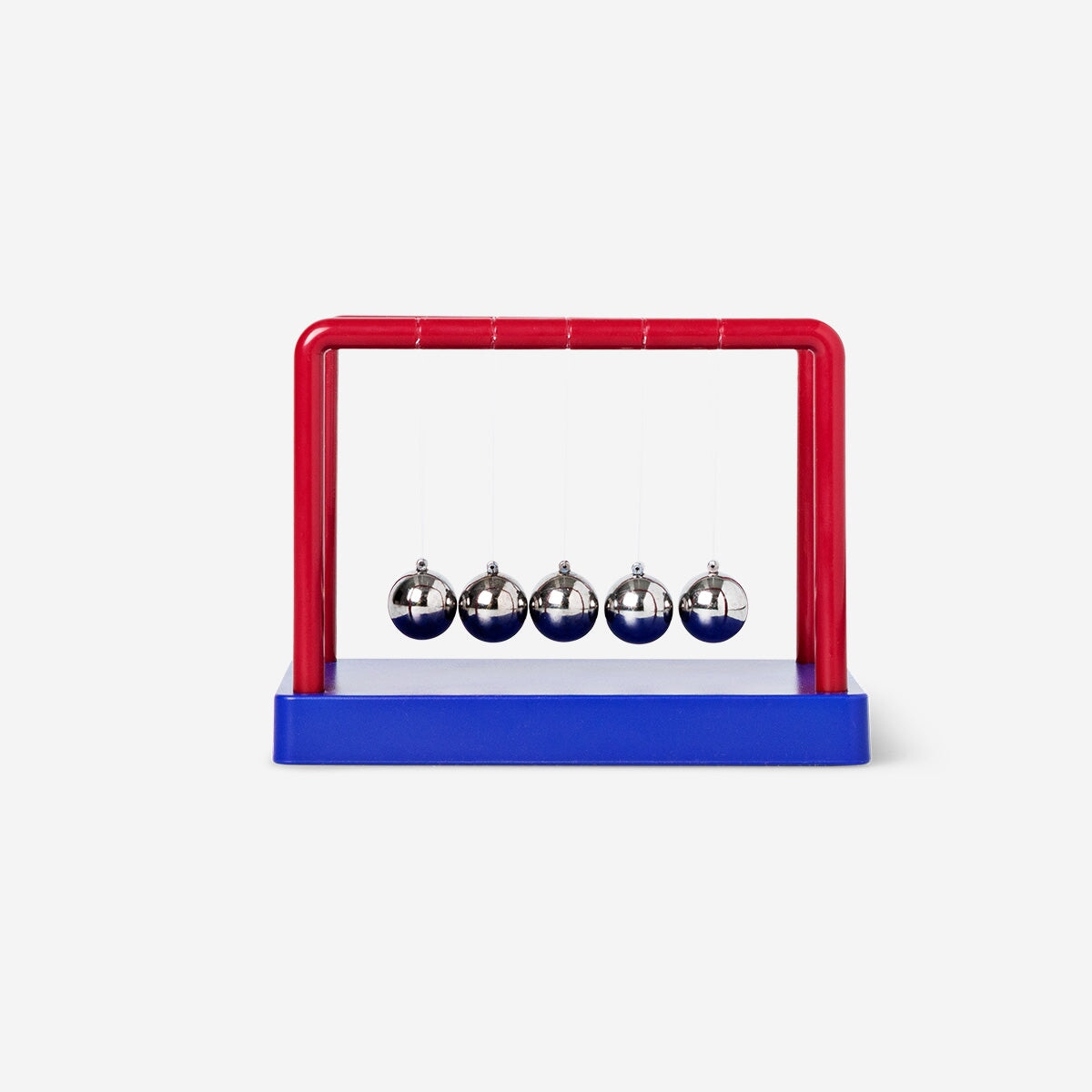 Blue and red Newton's cradle gadget from Flying Tiger Copenhagen with swinging metal balls on strings.