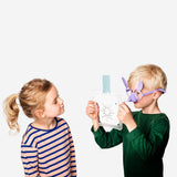 Flying Tiger Copenhagen nose-drawing game for four players, featuring colorful game pieces and drawing boards on a table.